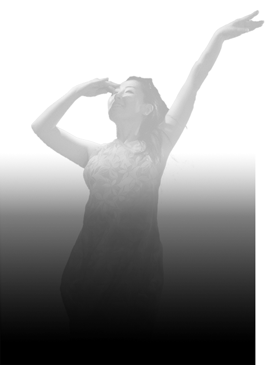暗闇にうっすら浮かび上がり踊る女性ダンサー
